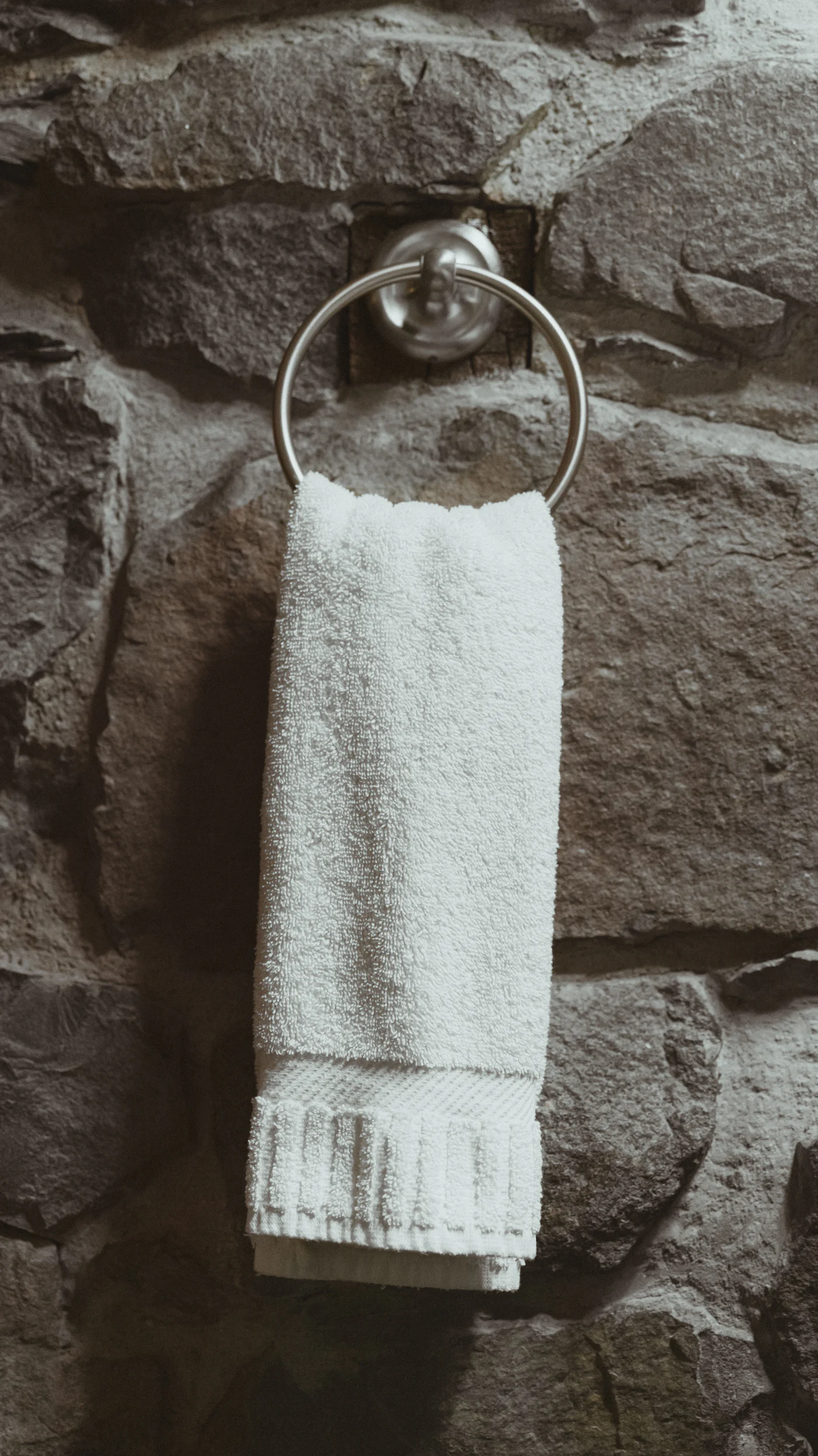 Serviette éponge blanche sur fond de pierre, ambiance spa